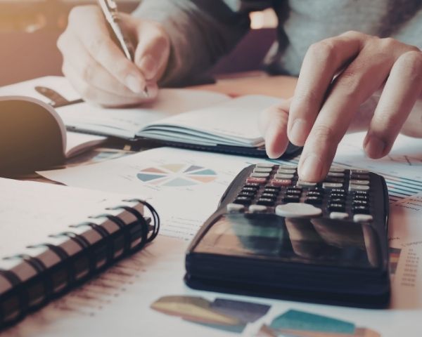 Pessoa calculando custos de impressão para avaliar outsourcing de impressão em uma PME