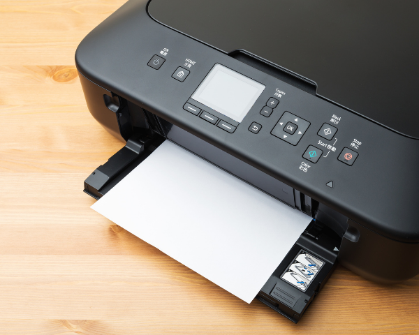 Impressora de mesa imprimindo uma folha com cartucho instalado no compartimento lateral